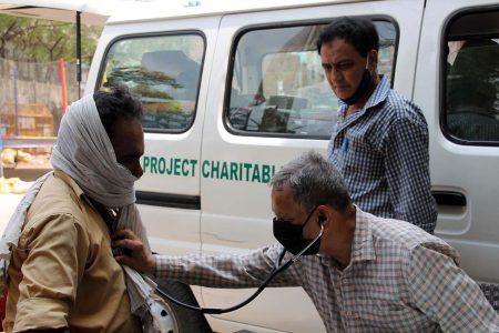 Dr. Arif untersucht einen Patienten in einem Außenbezirk